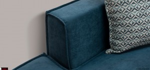 Μπλε πετρόλ γωνιακός καναπές-κρεβάτι με μαξιλάρια πλάτης και μοντέρνο design σε σαλόνι.