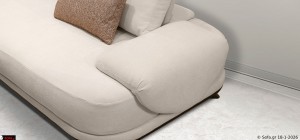 Κοντινό στο μπράτσο και το κάθισμα του τριθέσιου καναπέ Symmetry σε ανοιχτή εκρού απόχρωση, με κινητές πλάτες για ρύθμιση βάθους καθίσματος